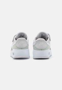 Baskets Nike Air avec une tige gris clair et vert menthe, dotées d'une finition texturée, d'un talon rembourré et d'une bande Velcro. Semelle blanche.
