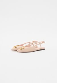 Beige slingback-flats med spiss tå. Glatt skinnmateriale, med en stor gullkjedeakcent på tåen og tynne stropper.