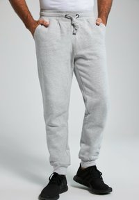 Lys grå bomulds joggers med elastisk talje, snøre lukning og sidelommer, med en tapered ben design.