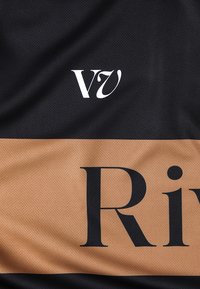 Μαύρο ύφασμα με λεία υφή, που διαθέτει λευκό λογότυπο "V7" στην κορυφή και μεγάλο μαύρο κείμενο "Riv" σε αντίθετη μπεζ λωρίδα από κάτω.