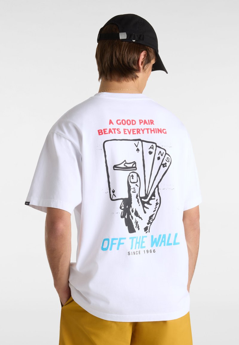 Weißes Baumwoll-T-Shirt mit einem Grafikdruck von einer Hand, die Spielkarten hält. Der Text lautet "EIN GUTES PAAR SCHLÄGT ALLES" und "OFF THE WALL."