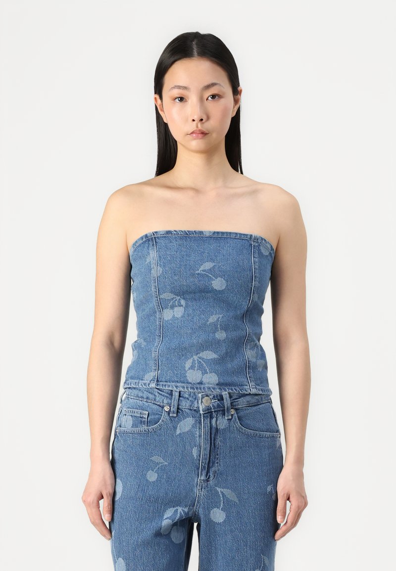 Denim strapless topp med tettsittende design, lys blå farge og subtile kirsebærmønster. Kombinert med matchende høyt midje jeans.