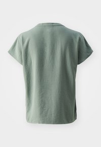 Lys grønn kortermet skjorte med en avslappet passform, myk tekstur og sømdetalj i kanten. Rund hals og minimalistisk design.