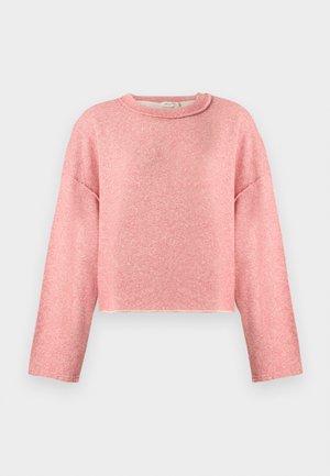 Myk rosa genser med rund hals og lange ermer, avslappet passform og noe kortere kant, vist mot en enkel lys bakgrunn.