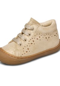 Scarpa per bambini in camoscio beige con motivi decorativi perforati, suola in gomma testurizzata e lacci beige scintillanti annodati a fiocco.