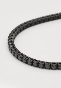 Collier en pierre noire comprenant une série de montures carrées avec des pierres facettées rondes. Fini lisse, design de bande fine.