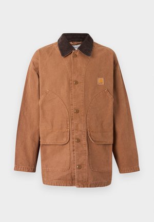 Καφέ μπουφάν από καμβά με γιακά από κορδόνι, κλείσιμο με κουμπιά στο μπροστινό μέρος και δύο μεγάλες τσέπες-μπαλώματα. Διαθέτει μπαλώμα λογότυπου στο στήθος.