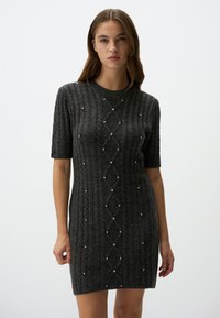 Robe courte grise à côtes avec des manches courtes, ornée d'un motif en losange enrichi de petites perles, fabriquée dans un tissu texturé et doux.