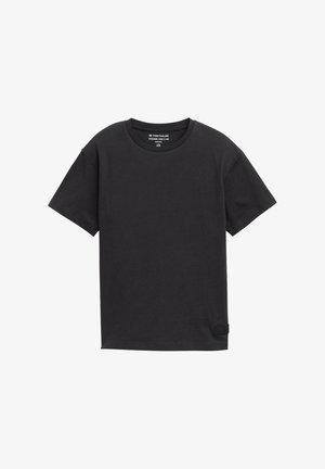 Schwarzes, übergroßes T-Shirt aus weicher Baumwolle. Verfügt über einen runden Halsausschnitt und kurze Ärmel. Inkludiert ein kleines Markenlabel an der Seite.