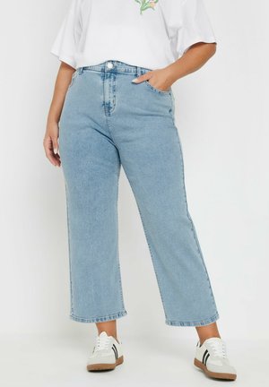 Light blue denim wide-leg jeans with a high waist, featuring front pockets and a clean hem. Paired with white sneakers.