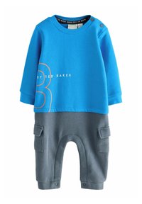 Top azul de manga larga con estampado de números naranjas y pantalones grises con bolsillos laterales. Tejido suave, diseño informal y cierre de botones.