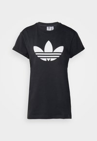 Juodas medvilnės marškinėliai su trumpomis rankovėmis ir dideliu baltu Adidas Trefoil logotipu su trimis horizontaliomis juostelėmis po juo.