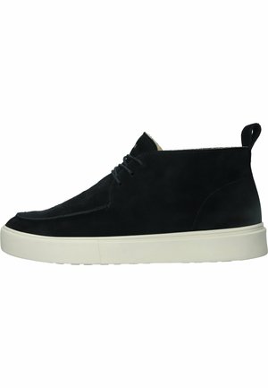 Botín negro de ante hasta el tobillo con punta redondeada, suela de goma blanca y un diseño sencillo de cordones. Cuenta con una pequeña lengüeta en el talón.
