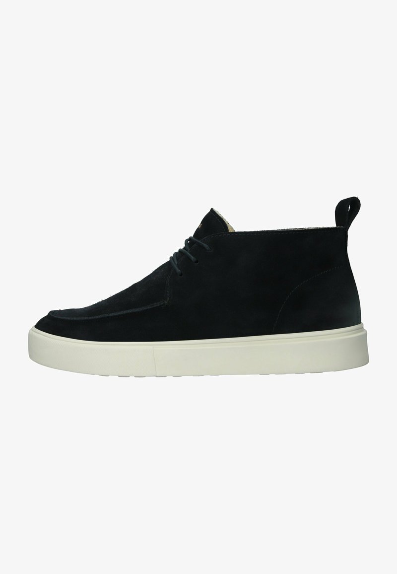 Botín negro de ante hasta el tobillo con punta redondeada, suela de goma blanca y un diseño sencillo de cordones. Cuenta con una pequeña lengüeta en el talón.