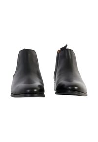 Botas de tobillo de cuero negro con un acabado liso, paneles laterales elásticos y una lengüeta en el talón para facilitar el calzado. Suelas de goma resistentes.