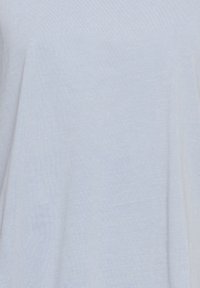 Tissu gris clair uni avec une texture subtile et des plis doux, sans motifs distincts ni objets visibles.