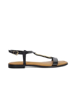 Sandales en cuir noir avec une finition texturée, bride de cheville ajustable, semelle plate, détails en accent doré et design à bout ouvert.