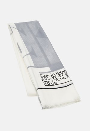 Złożony biało-szary szal z logo Calvin Klein i adresem w Nowym Jorku nadrukowany w czarnym tekście na jednym końcu.