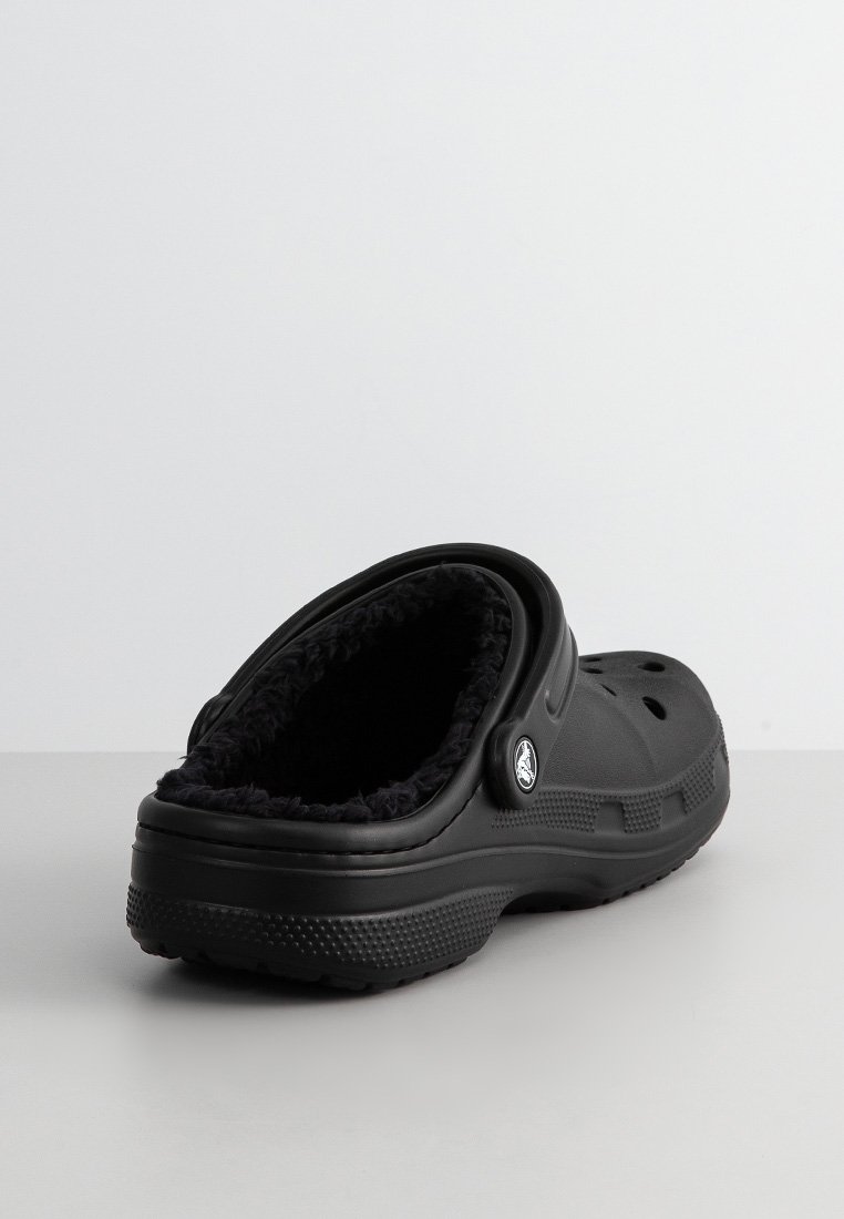 Zwarte klompen met een zachte, textuurgevoelige voering, open achterkant en geperforeerde bovenkant voor ventilatie. Voorzien van een logo-accent aan de zijkant.
