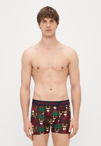 Boxer briefs in a burgundy color with a festive reindeer and gift pattern. Elastic waistband features "JACK & JONES" branding in black.