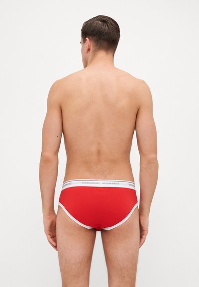 Rote Boxershorts mit einem weißen Bund, der das Logo "DSQUARED2" trägt. Glattes Material, körpernahe Passform und eine tief geschnittene Form. Von hinten betrachtet.