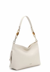 Biała skórzana torebka o fakturowanej powierzchni, z zaokrąglonym górnym brzegiem i paskiem z ogniw łańcucha z złotymi i przezroczystymi akcentami.