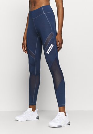 Leggings navy avec des panneaux en maille, dotés d'une taille haute et de coutures contrastées. Le logo Puma est affiché en blanc sur la cuisse.