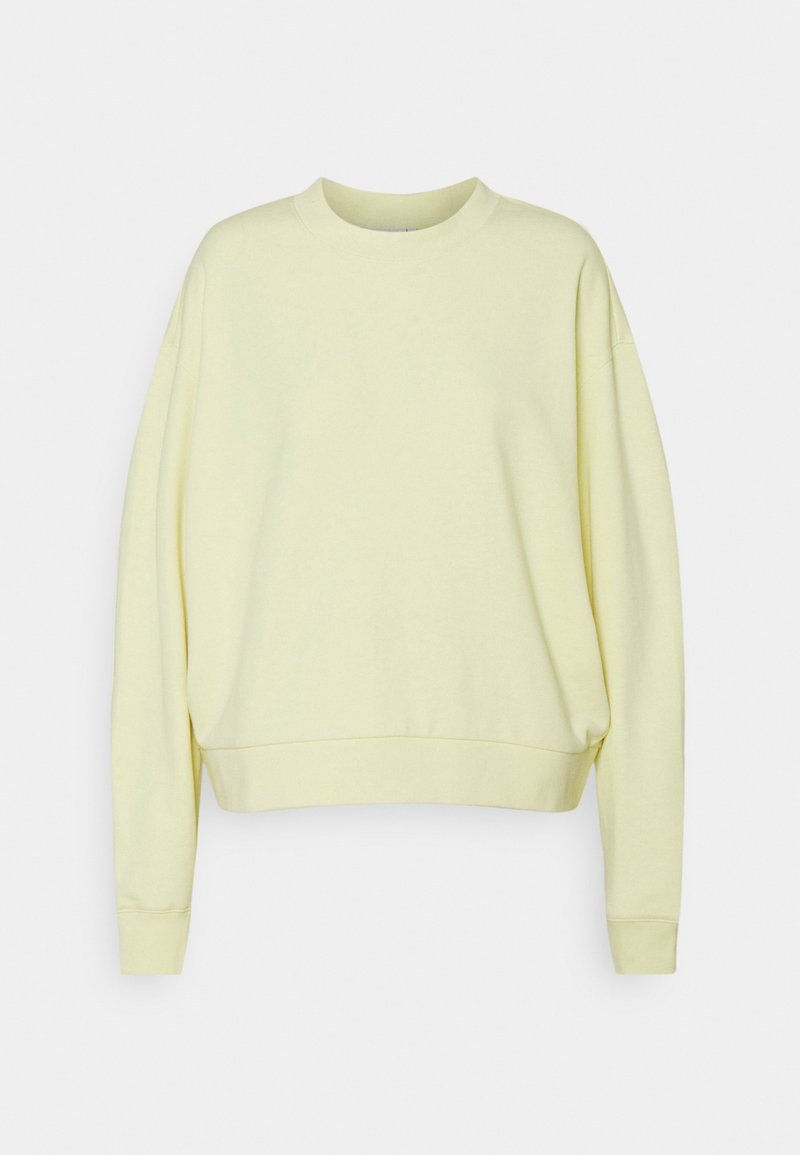 Sweat-shirt jaune à col rond, épaules tombantes et poignets côtelés. Tissu doux et coupe décontractée. Design simple et sans ornement.