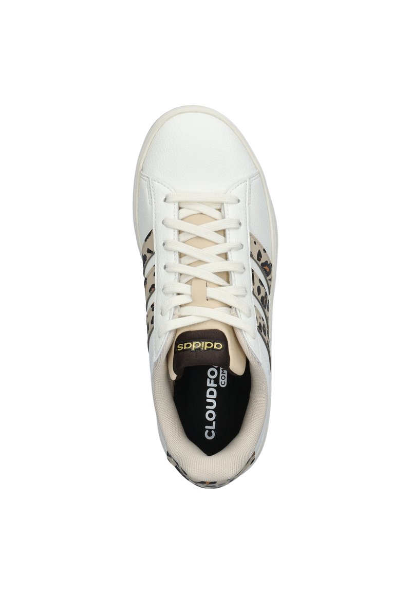 White sneaker with textured synthetic upper, beige accents, and brown leopard print stripes. Features white laces and padded interior.