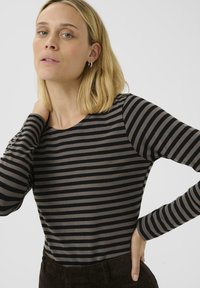 Stribet langærmet top med skiftende sorte og grå striber, rund halsudskæring og en tætsiddende silhuet. Stoffet er glat og let.
