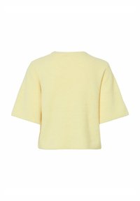 Krótki rękaw, żeberkowy top w jasnym żółtym kolorze. Posiada prosty okrągły dekolt oraz luźny krój, z teksturowanej tkaniny i bez widocznych zapięć.