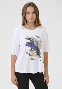 T-shirt en coton blanc à manches courtes et coupe loose, arborant un imprimé abstrait multicolore dans les tons de bleu, or et noir sur le devant.