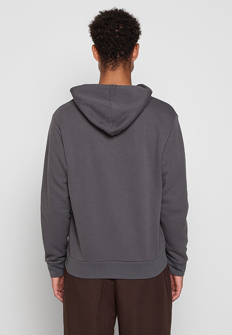 Szary kaptur z miękkiej tekstury, z luźnym krojem, ściągaczami na brzegu rękawów oraz dolnym hemie. Gładkie plecy bez dodatkowych detali.
