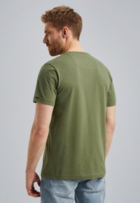 T-shirt in cotone verde oliva con maniche corte e collo rotondo. Design semplice, texture uniforme e dettagli di cucitura minimali.