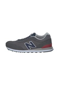 Grauer Sportschuh aus Mesh- und Wildledermaterialien, mit einer weißen Zwischensohle, roten Akzenten und einem auffälligen navyblauen 'N'-Logo.