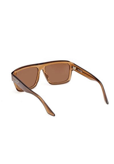 Lunettes de soleil à monture carrée transparente marron avec des verres teintés marron reposant sur une surface blanche.