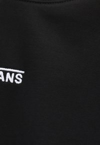 Czarna bawełniana tkanina z białym haftowanym napisem „JEANS”. Gładka tekstura, klasyczny krój i okrągły dekolt.