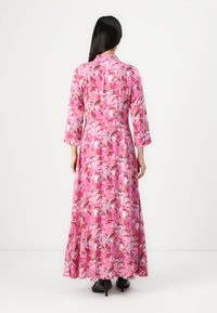 Maxikjole i et livligt pink blomsterprint med lange ærmer og en afslappet silhuet, lavet af letvægtsstof, har en svævende nederdel.