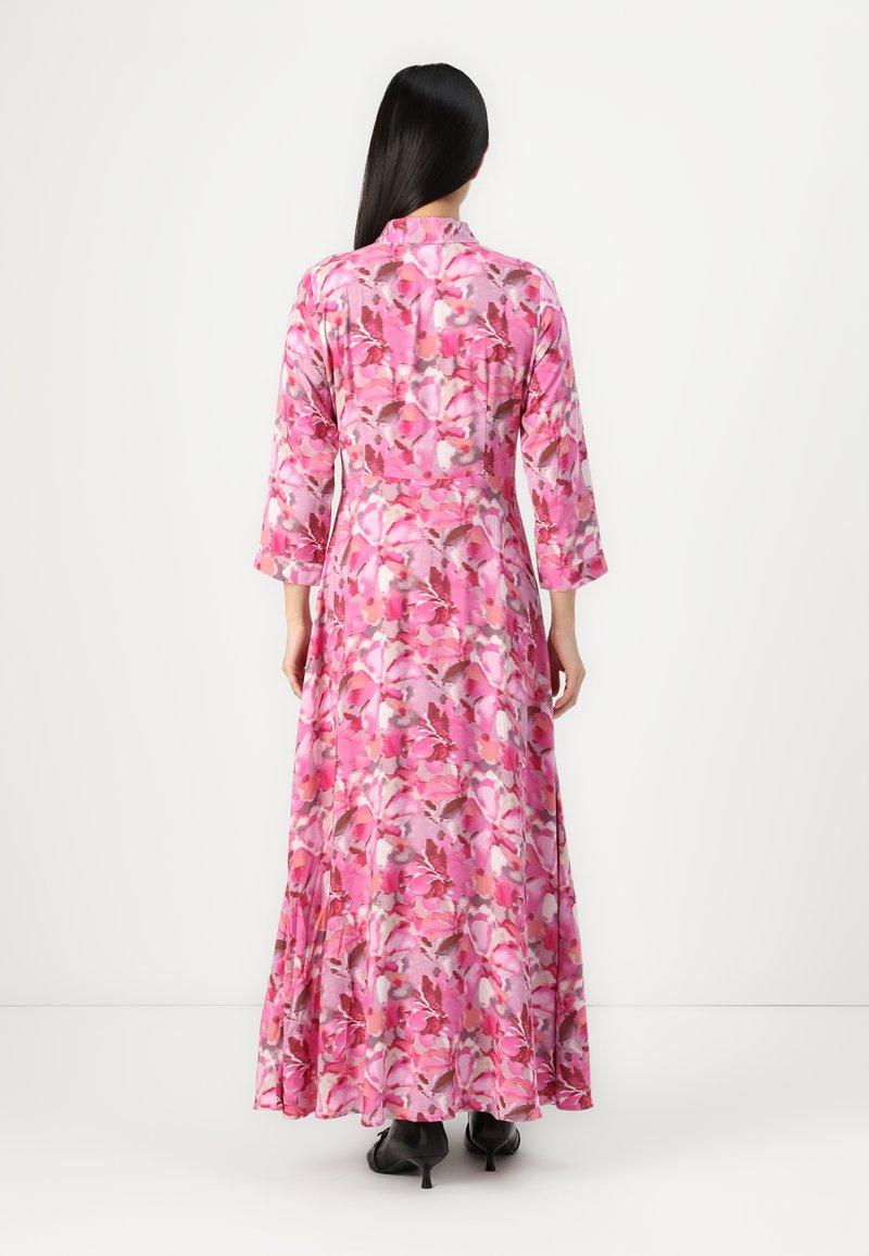 Maxi sukienka w intensywnym różowym kwiatowym wzorze z długimi rękawami i luźnym krojem, wykonana z lekkiego materiału, z falującą spódnicą.