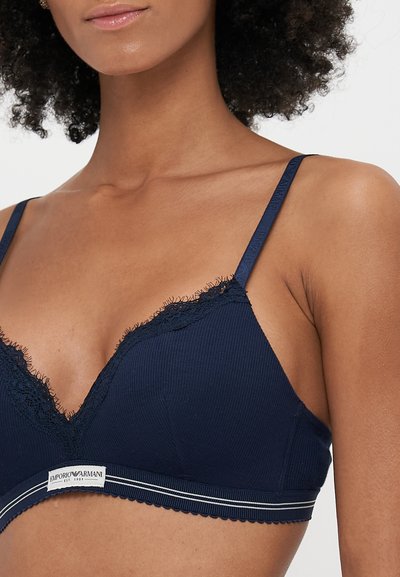Tengeréskék bordás bralette csipkés szegéllyel, állítható pántokkal és logós zsinórral ellátott hullámos bandával. Simább textúra, minimalista dizájn.