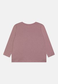 T-shirt à manches longues en tissu mauve doux, avec un col rond classique et un ourlet droit aux bords cousus, conçu pour le confort et la polyvalence.