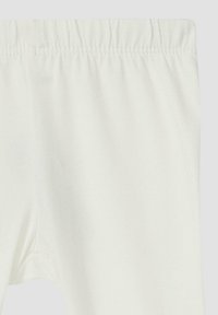 Weiße Baumwollleggings mit einem elastischen Bund und glatter Textur, ohne sichtbare Muster oder Akzente.