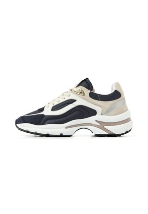 Chunky sneaker with navy, beige, and white panels, white laces, and thick white sole with beige detailing.