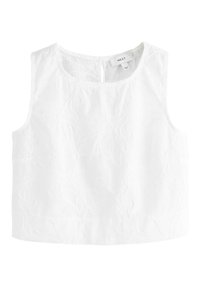 Top bianco senza maniche con ricami floreali, scollatura tonda e chiusura con bottone sul retro. Realizzato in tessuto leggero.