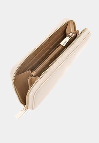 Beige zippered wallet with textured exterior, gold-toned hardware, and a spacious interior featuring multiple card slots and a central zipper pocket.