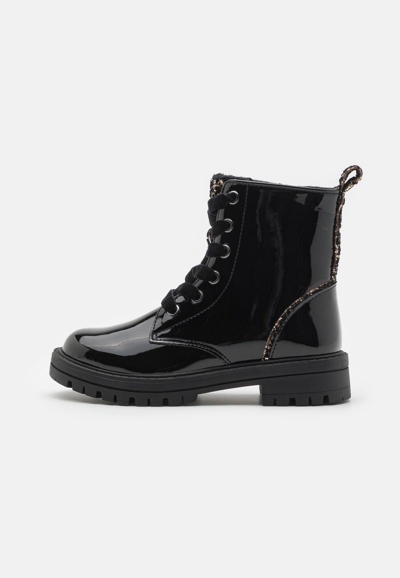 Stivaletti alla caviglia in pelle verniciata nera con suola intermedia texture, chiusura con lacci e cuciture decorative lungo il colletto. Include una linguetta per facilitare l'indossamento.