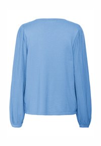 Svetlo modra bluza z dolgimi rokavi, okroglo izrezano, mehke teksture in nabrano detajliranje ob rokavih. Enostaven, sproščen kroj.