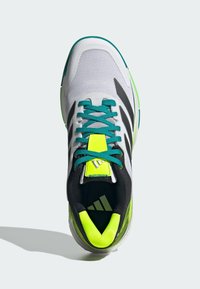 Sport shoes with a mesh upper in white, black stripes, and teal laces. Features a yellow accent on the tongue and a green sole.