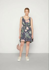 Vestido floral com fundo azul-marinho, design sem mangas e saia evasé. Apresenta flores em tons de rosa e verde; combinado com uma pequena bolsa.