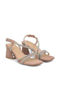 Sandalias de tacón en rosa pálido con tiras de rhinestones plateados, diseño de punta abierta y tacón cuadrado con un acento plateado brillante. Material suave texturizado.